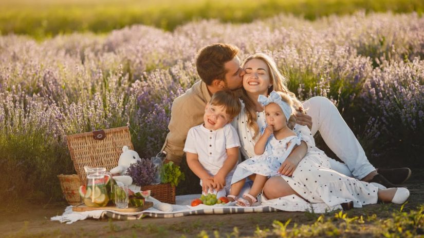 A joyful family enjoying a picnic together in a scenic lavender field during summer.